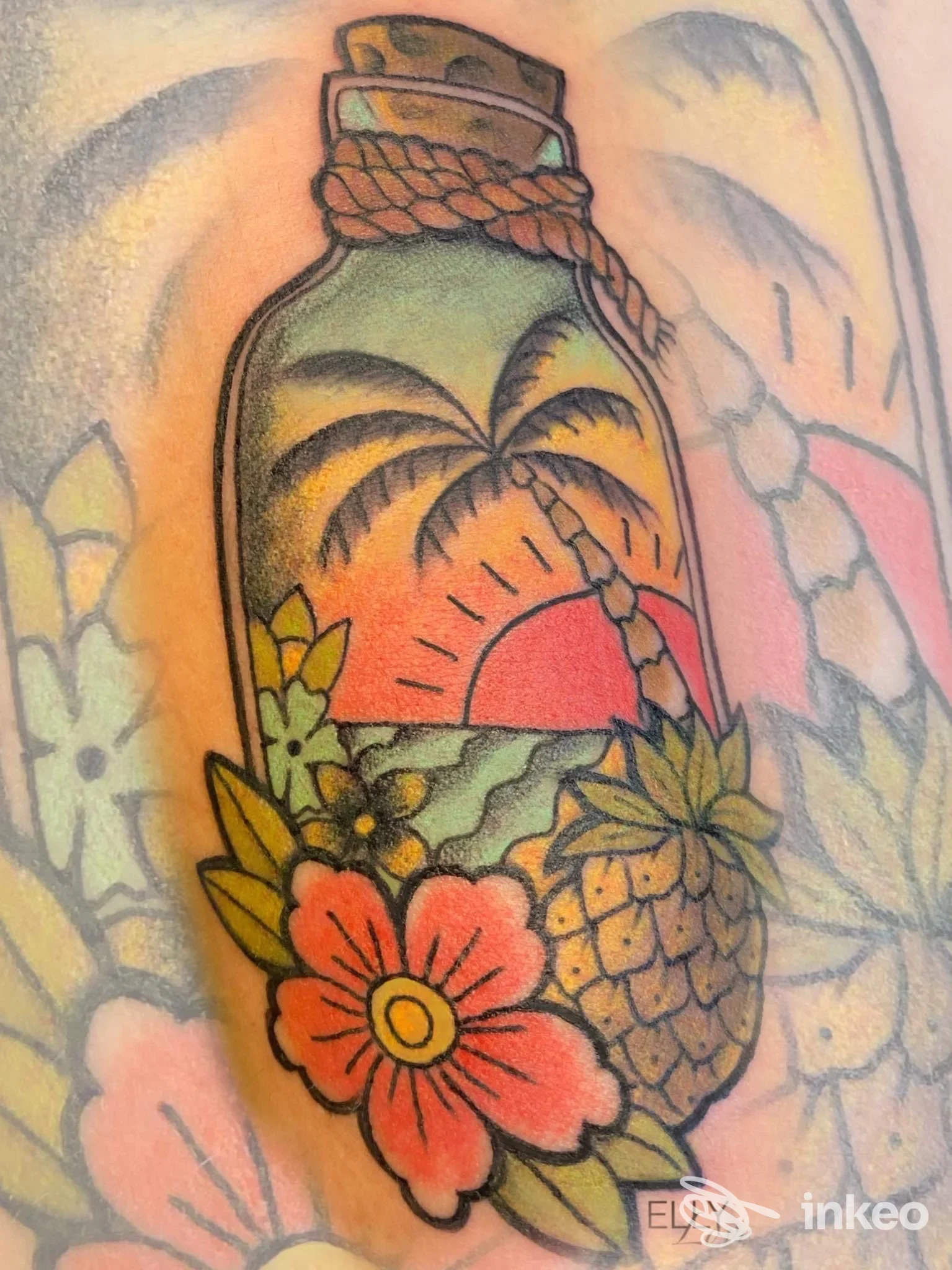 Tattoo su pelle raffigurante una bottiglia con paesaggio tropicale: palme, tramonto e fiori colorati sull'avambraccio, stile inchiostro definito e vivace.