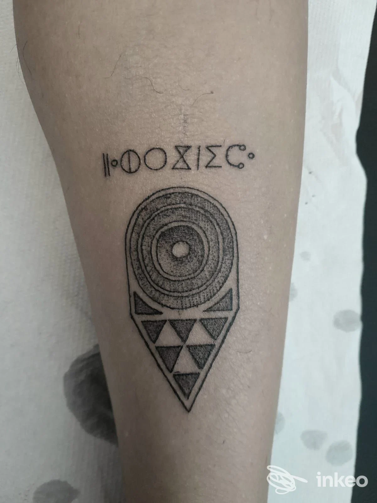 Tatuaggio geometrico a puntinatura sull'avambraccio con simboli lineari sopra, lavoro di Enrico Ristori Tattoo Artist, Livorno.