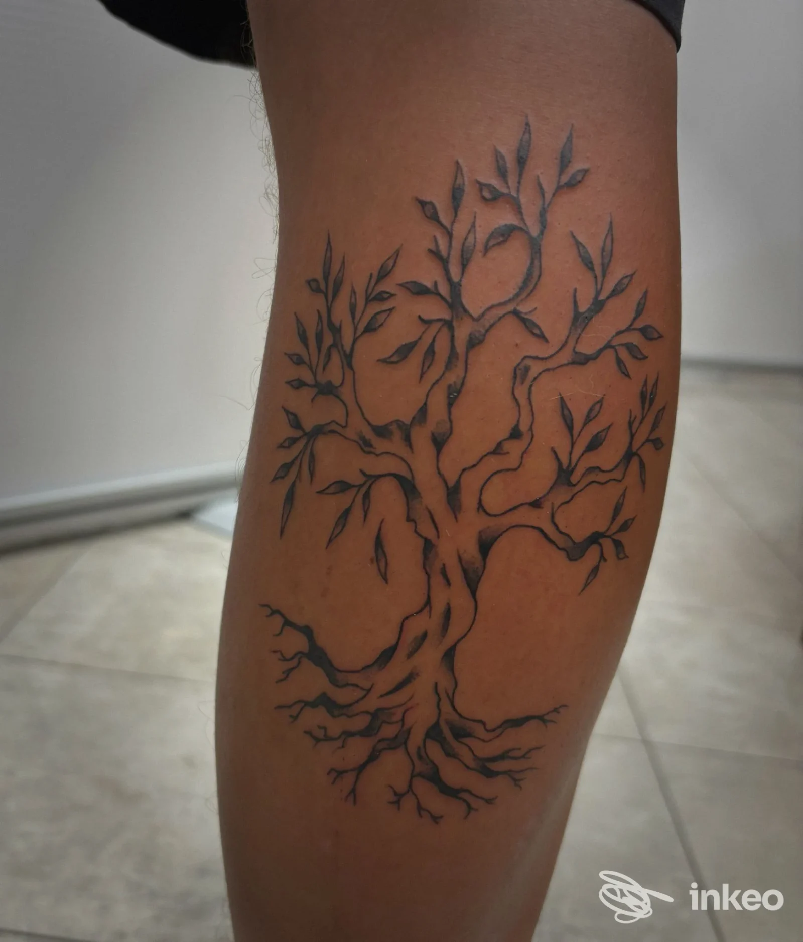Tatuaggio stilizzato a forma di albero in nero sul polpaccio, eseguito da Admiral Tattoo a Massa.