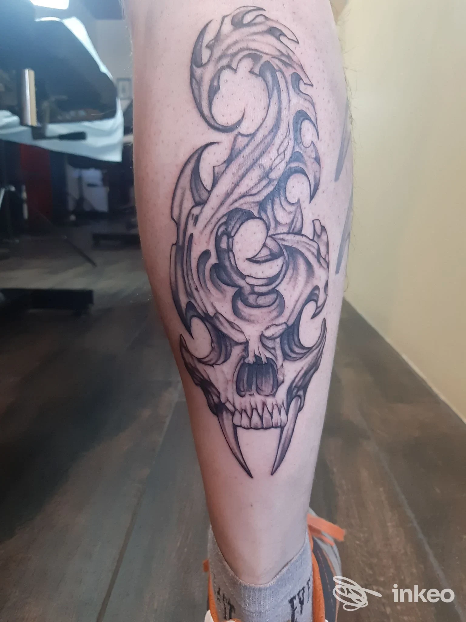 Tatuaggio nero e grigio a forma di teschio e volute sul polpaccio, foto fornita da Afiordipelle Tattoo, Arezzo.