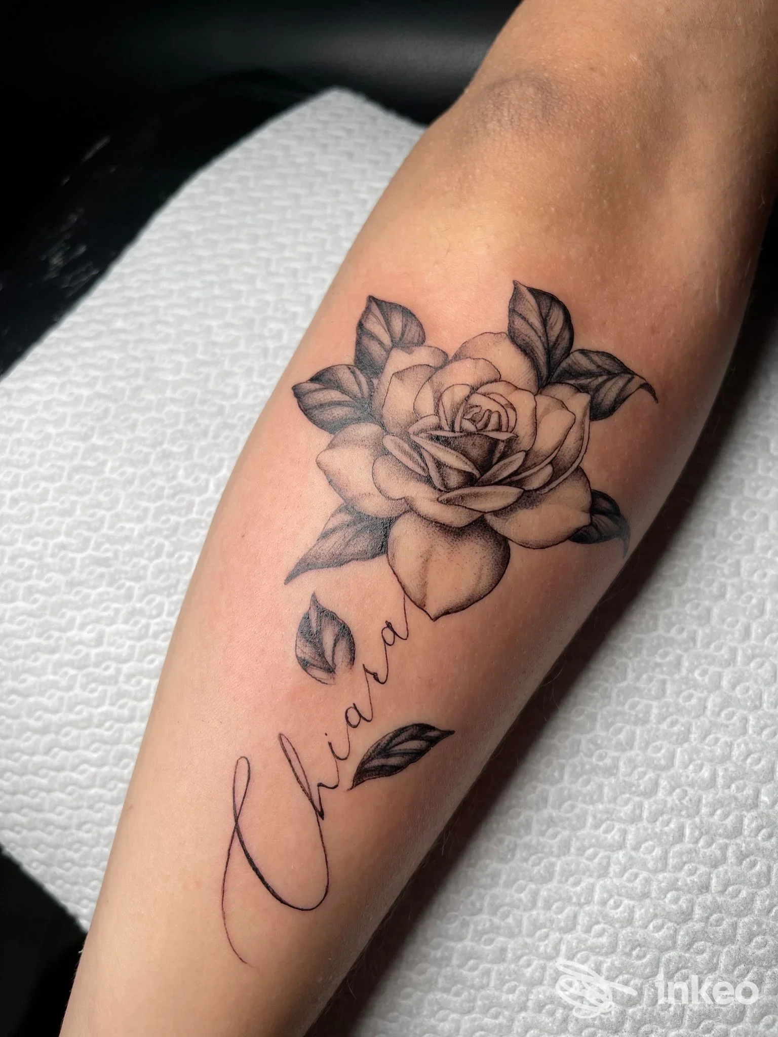 Tatuaggio rosa nero/grigio con nome calligrafico sull'avambraccio, Araba Fenice Tattoo Studio, Ponsacco.