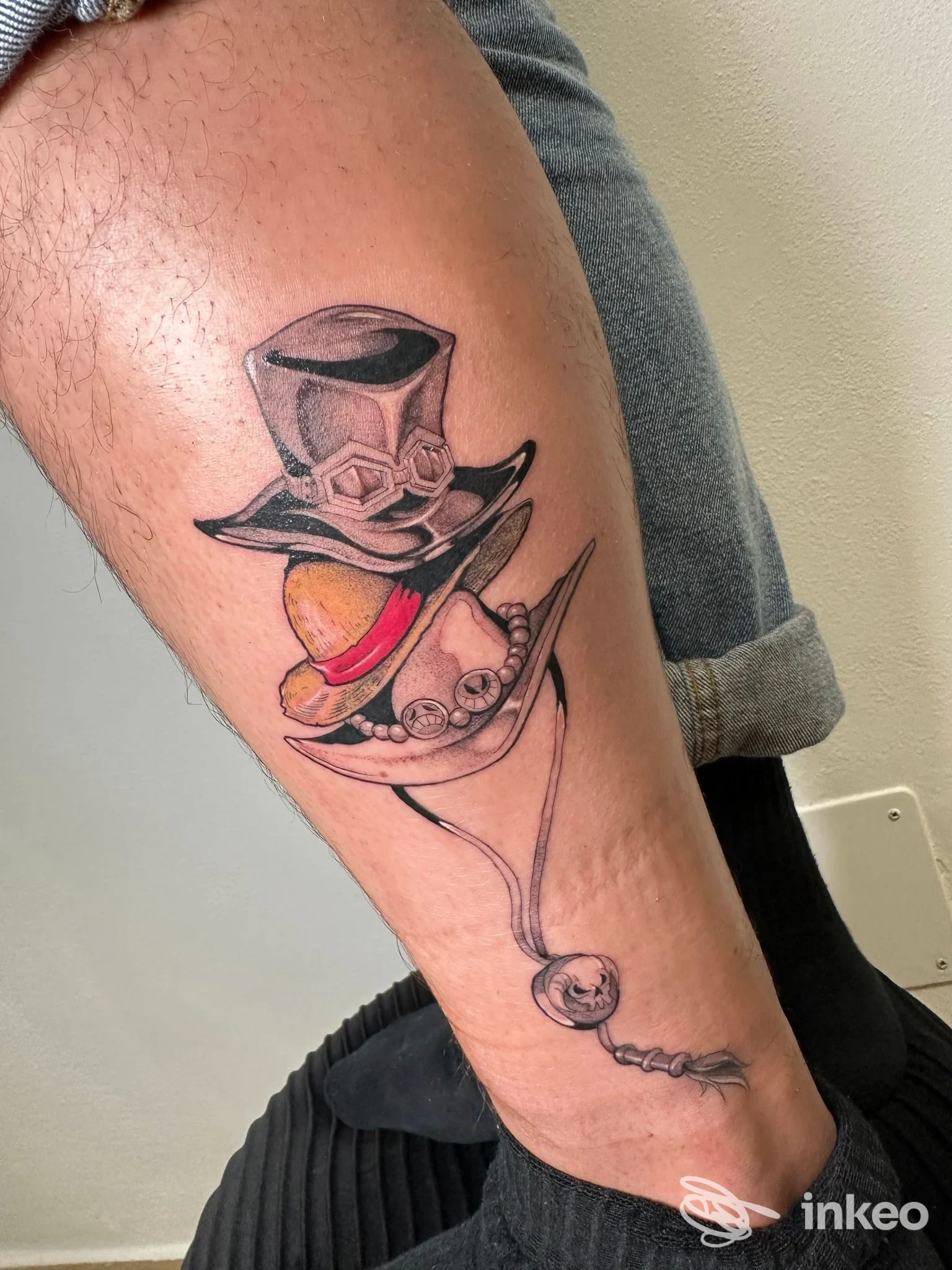 Tatuaggio colorato su polpaccio con due cappelli sovrapposti, Araba Fenice Tattoo Studio, Ponsacco.