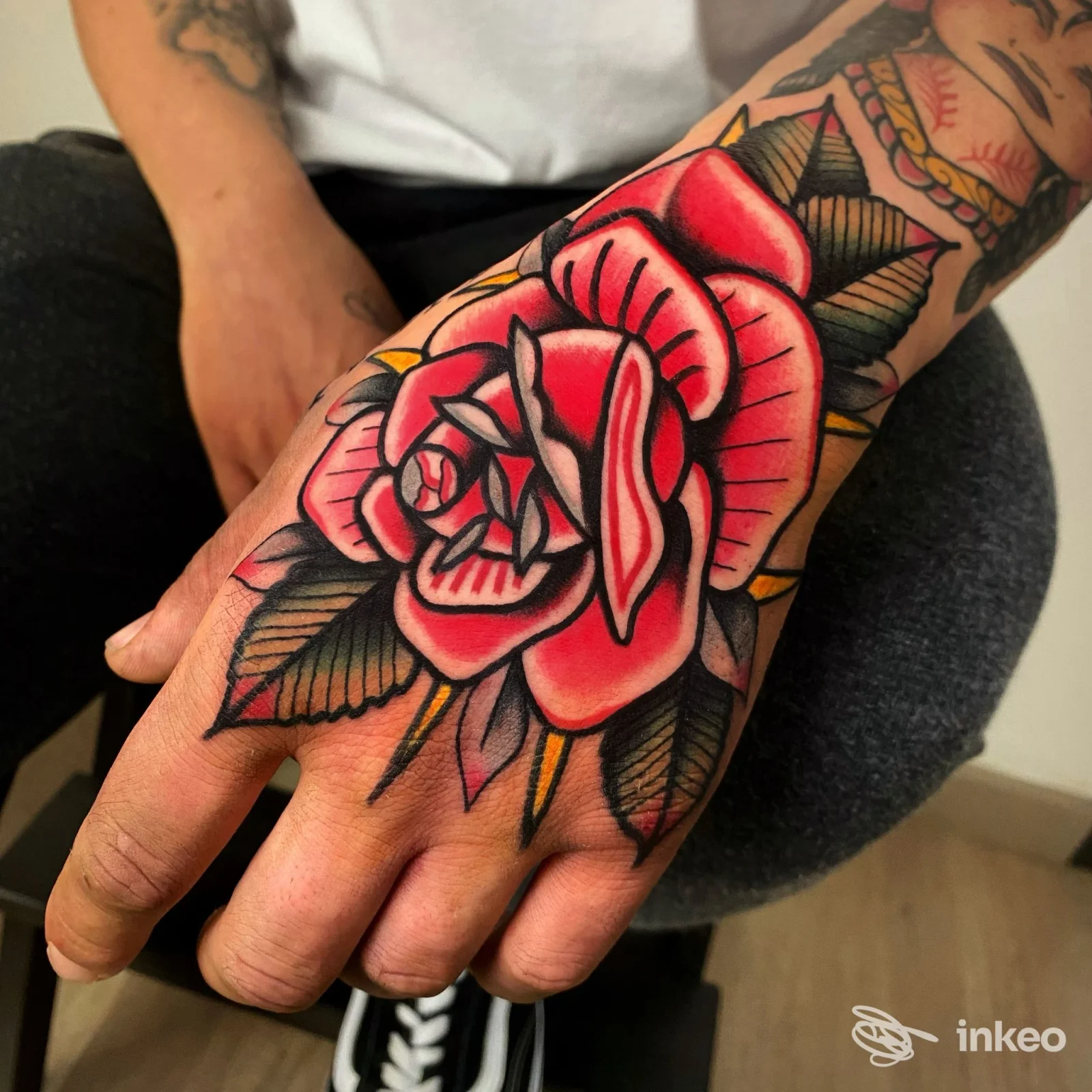 Grande tatuaggio a rosa tradizionale sul dorso della mano, foto fornita da BLACK FLOW Tattoo Studio, Firenze.