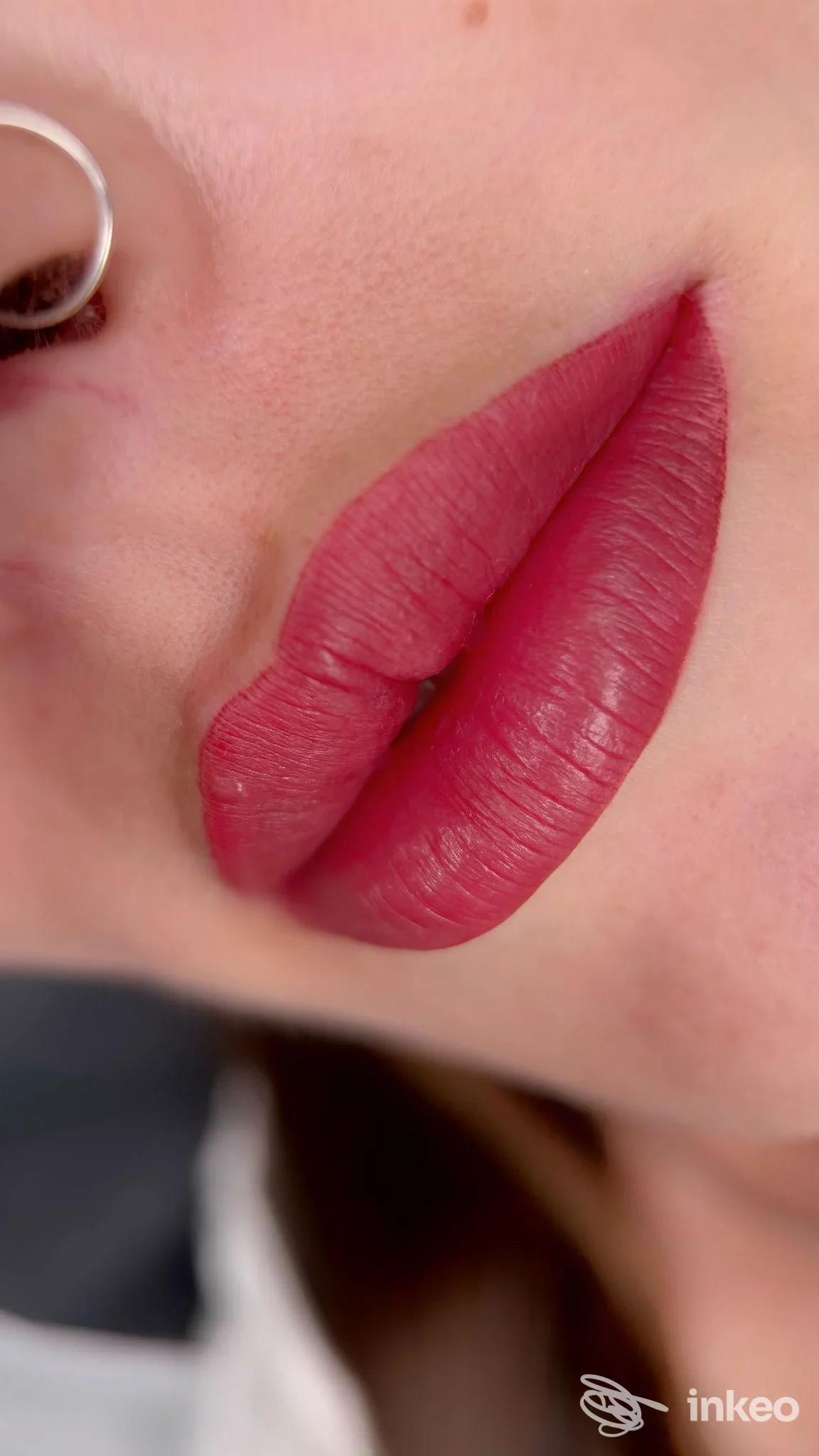 Dettaglio labbra con trucco permanente rosso su pelle reale e piercing al naso. Foto studio Bellezza Permanente di Alena Gubernatorova, Firenze.