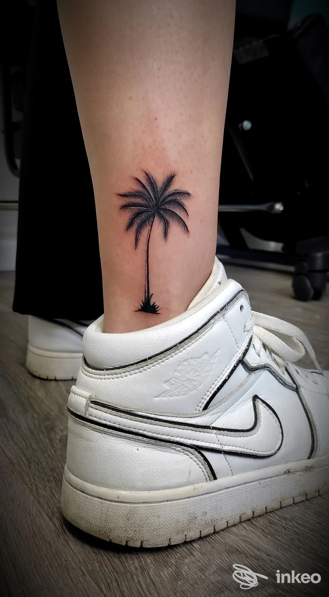 Tatuaggio minimal di una palma nera sul polpaccio, foto inviata da Al Tattoo Studio a Firenze.