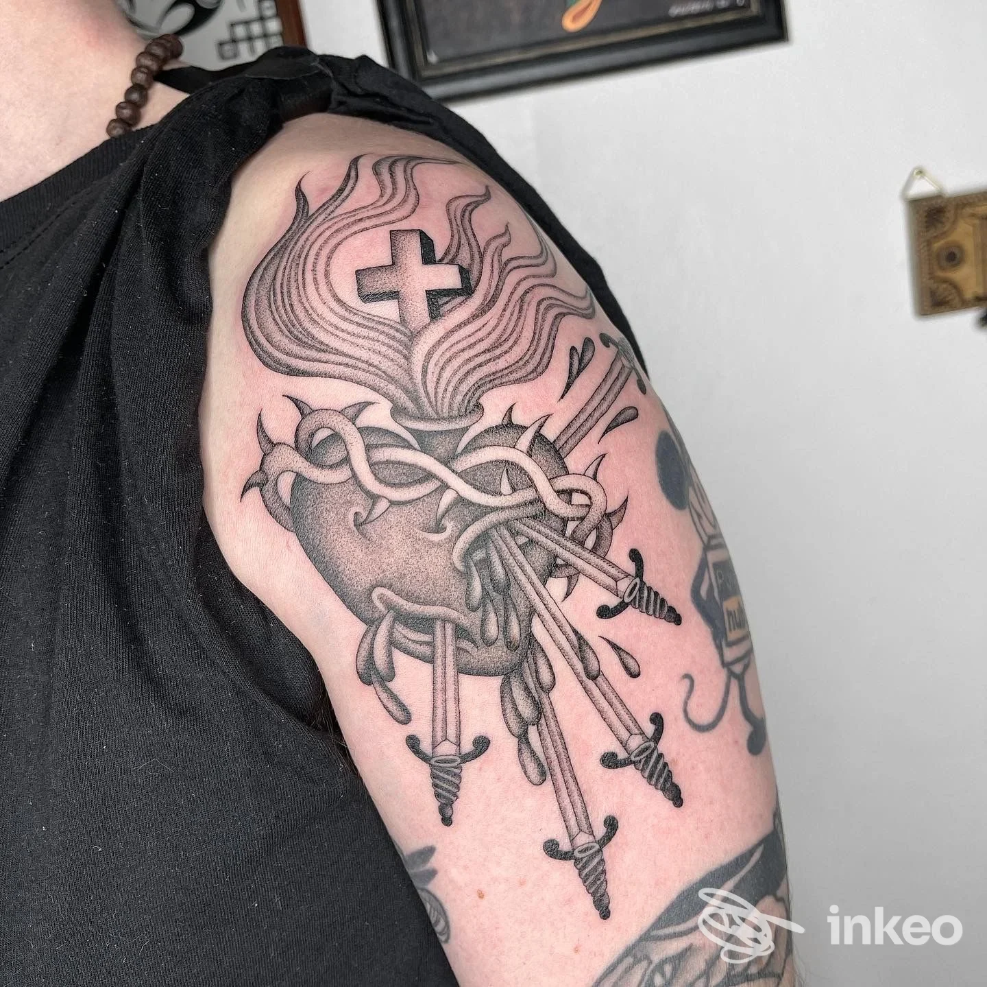 Tatuaggio in bianco e nero sul braccio/spalla con cuore trafitto da pugnali, scatto realizzato per Cry Baby Tattoo Parlour ad Arezzo.