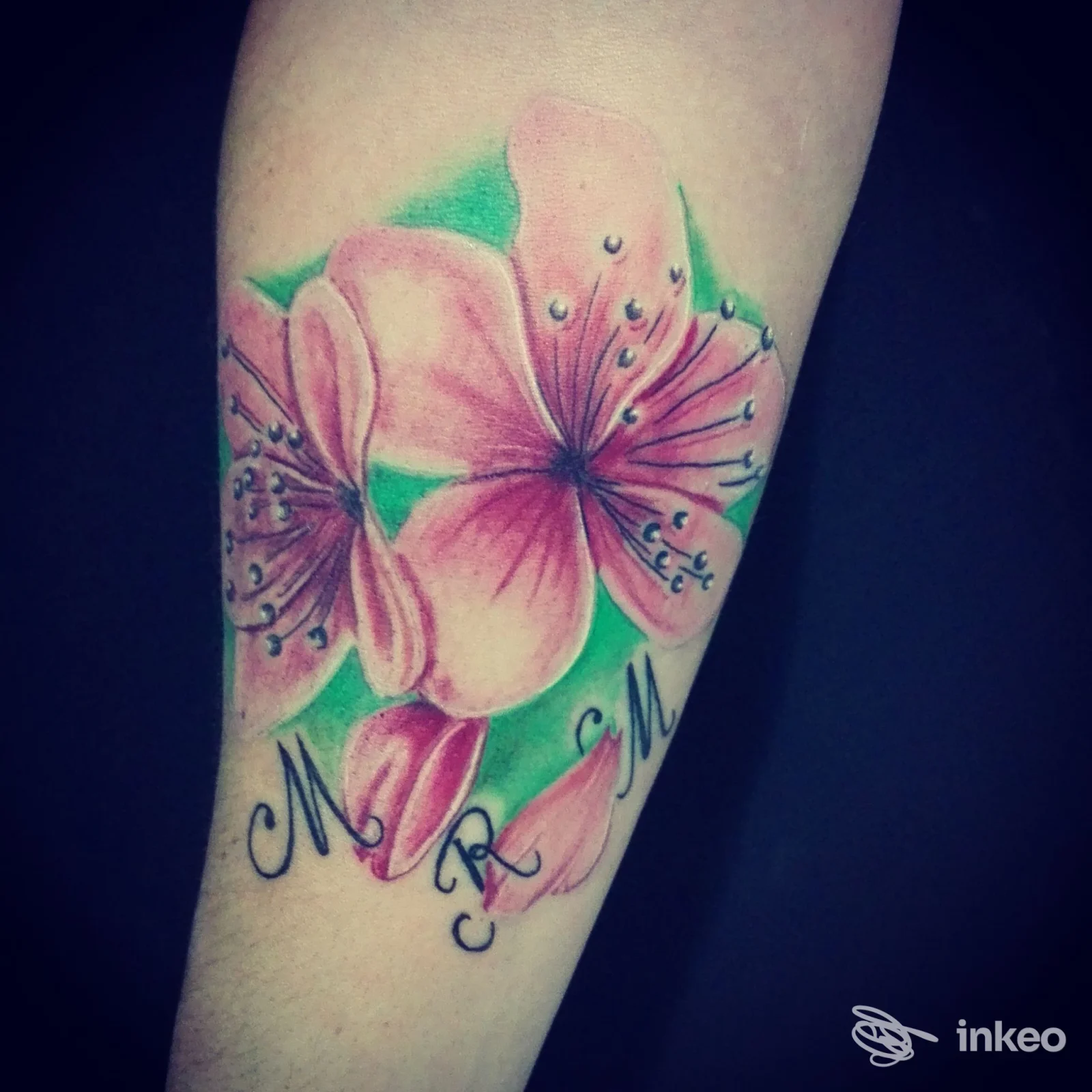Tatuaggio floreale a colori con fiori rosa su avambraccio, realizzato da Cuore Nero - Tattoo e Piercing a Livorno, dettaglio di sfumature e contorni.