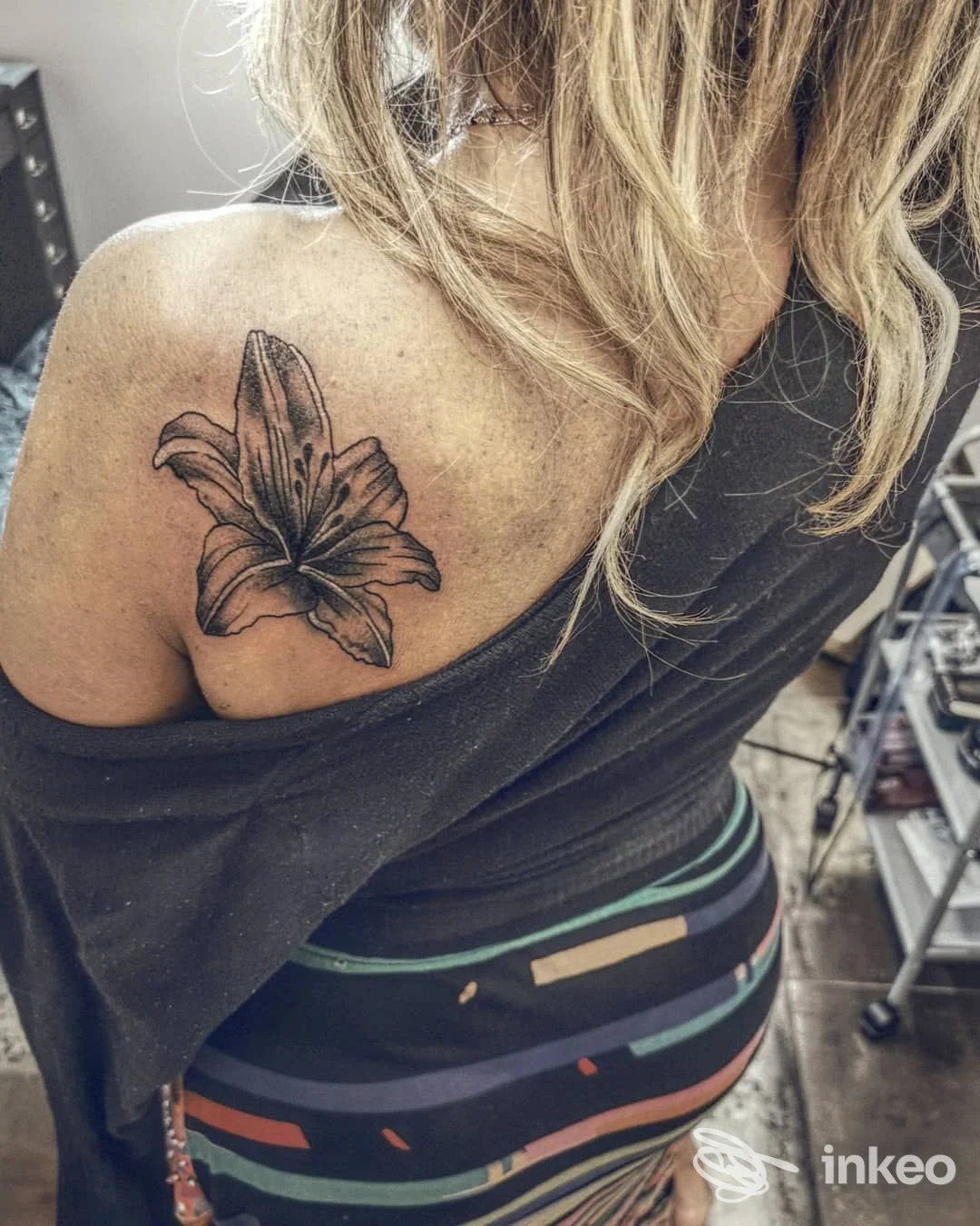 Tatuaggio a forma di giglio in bianco e nero sulla scapola sinistra, fotografia scattata nello studio ElCagliador Tattoo Studio a Firenze.
