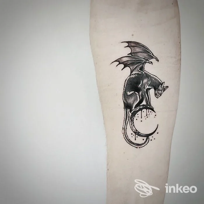 Avambraccio con tatuaggio nero/grigio di creatura alata; immagine fornita da Delectasti Studio d'Arte Tatuatoria, Carrara.