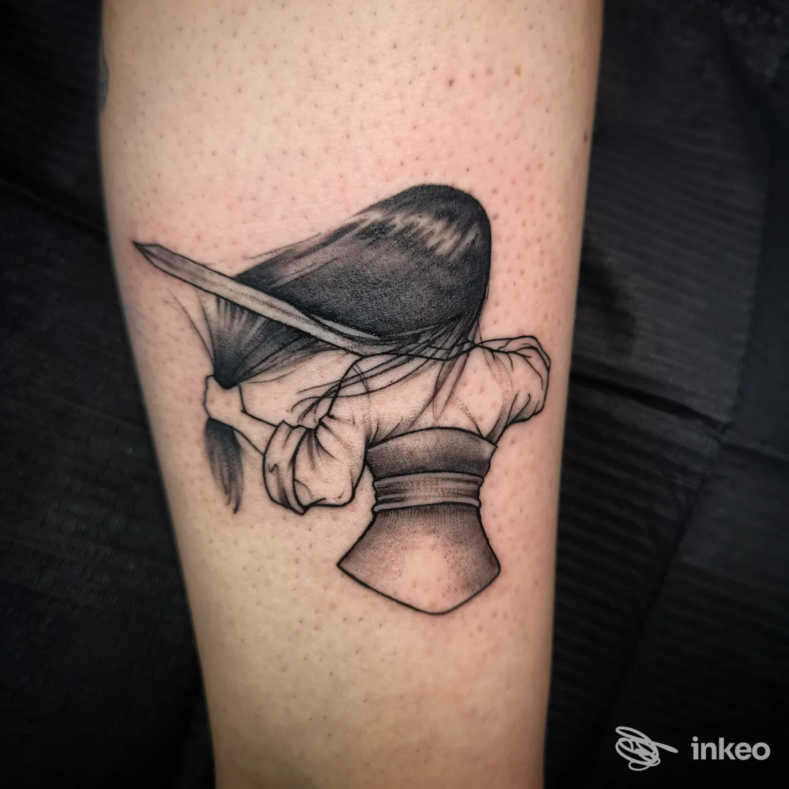 Tatuaggio in bianco e nero di una figura vista da dietro, realizzato su pelle dell'avambraccio. ForeverInk Tattoo, Lucca.