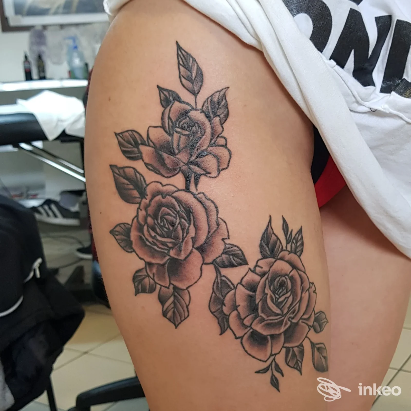 Dettaglio di un tatuaggio in bianco e nero con tre rose e foglie sulla parte alta della coscia; lavoro eseguito presso I.K.T TATTOO, Pistoia.