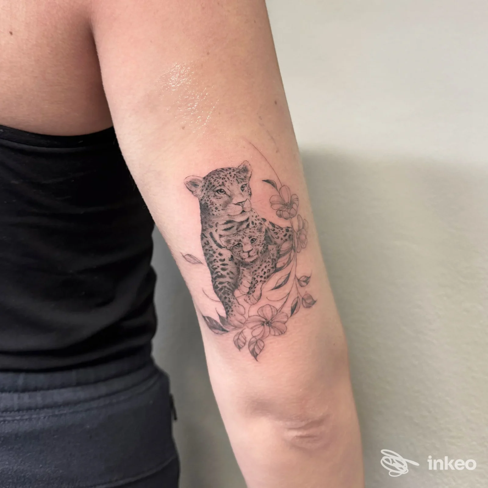 Tatuaggio in bianco e nero di due felini con fiori sull'avambraccio, INK LAB 22 TATTOO STUDIO, Poggibonsi.
