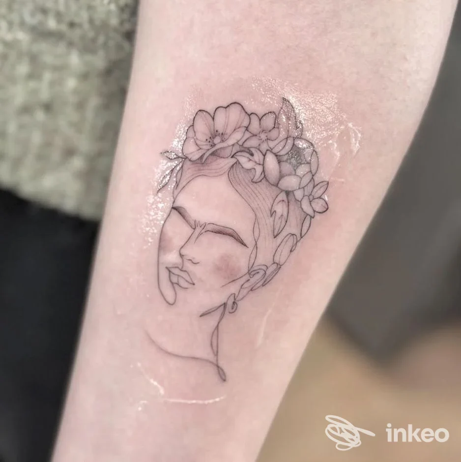 Tatuaggio linework su avambraccio: volto stilizzato con corona di fiori, INK LAB 22 TATTOO STUDIO, Poggibonsi.