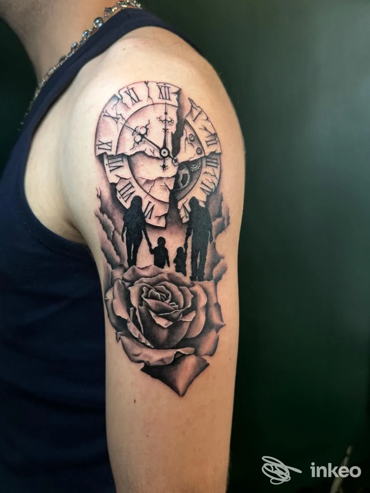 Tatuaggio black & grey sull'omero con orologio rotto, silhouette familiari e grande rosa, foto di Kairos Tattoo Studio, Firenze.