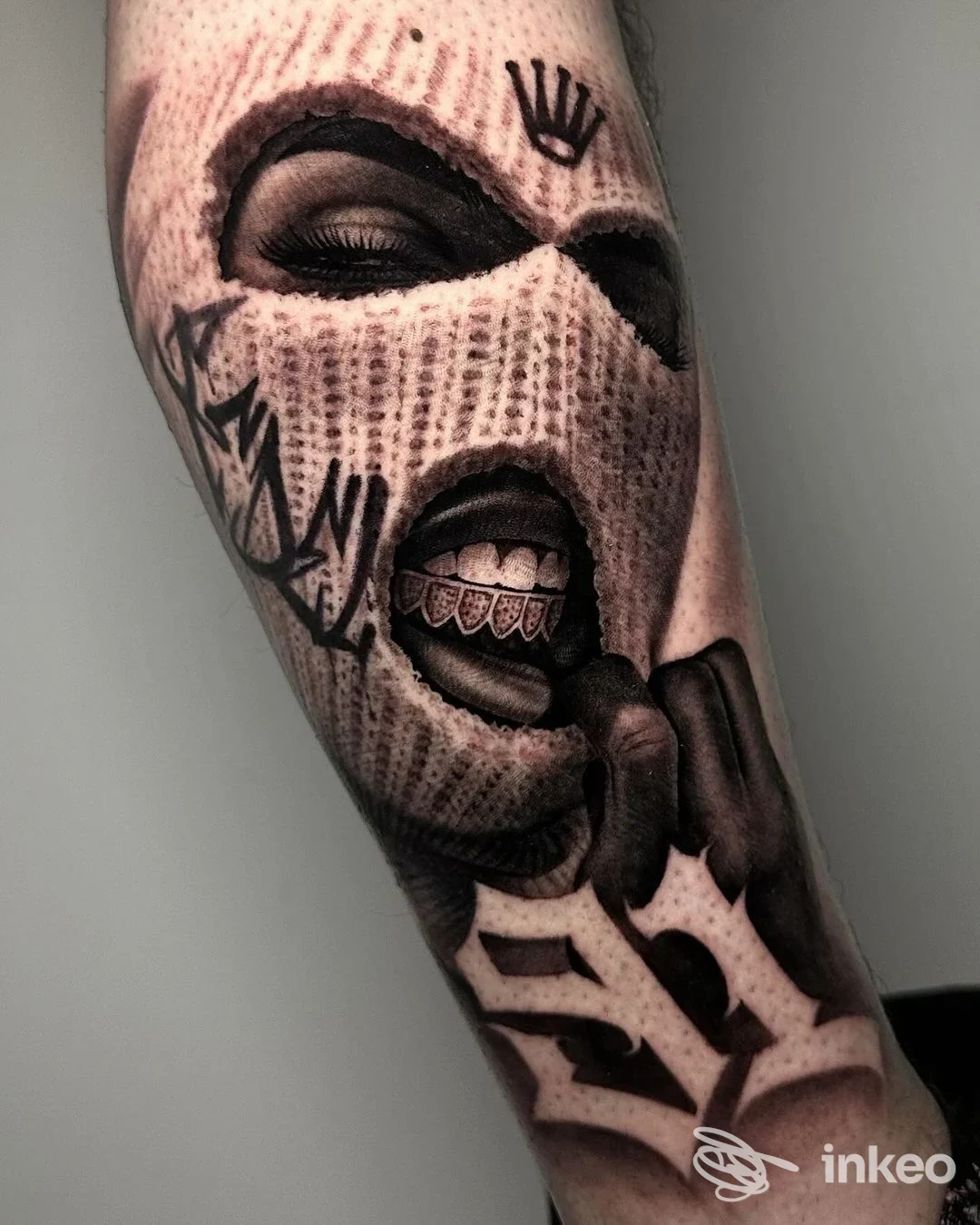 Tatuaggio su avambraccio con volto in passamontagna e bocca aperta, Liberty Ink Tattoo, Firenze.