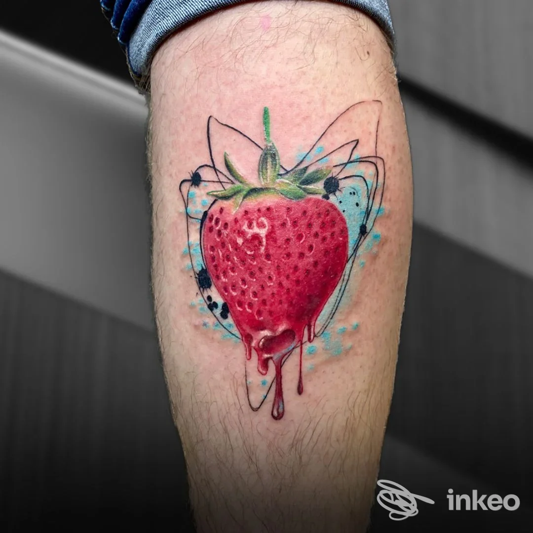 Tatuaggio di una fragola colorata su polpaccio, realizzato da Liberty Ink Tattoo a Firenze, con effetti acquerello e gocce rosse.