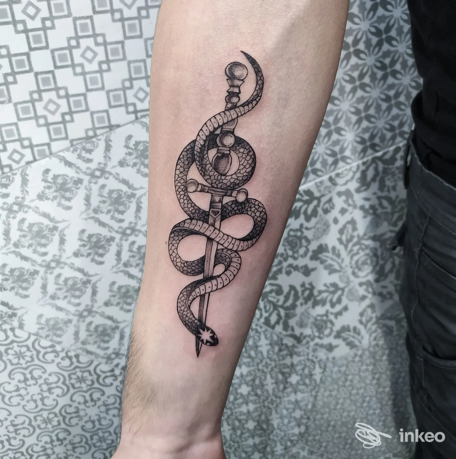 Tatuaggio blackwork su avambraccio con pugnale avvolto da serpente, foto inviata da Madame Black Tattoo, Livorno.