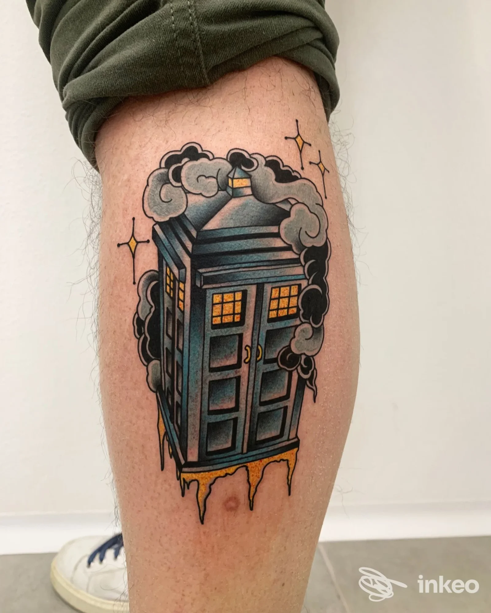 Tatuaggio su polpaccio raffigurante una cabina blu stilizzata con nuvole, foto fornita da Malatinta Tattoo a Poggio Basso.