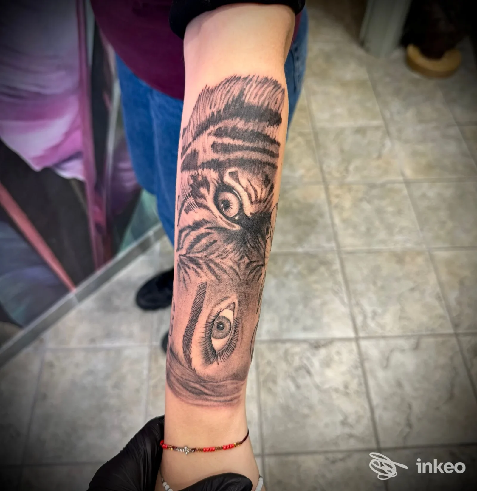 Tatuaggio realistico in bianco e nero sull'avambraccio presso Musa tattoo studio a Pietrasanta, dettagli di occhi e pelliccia.