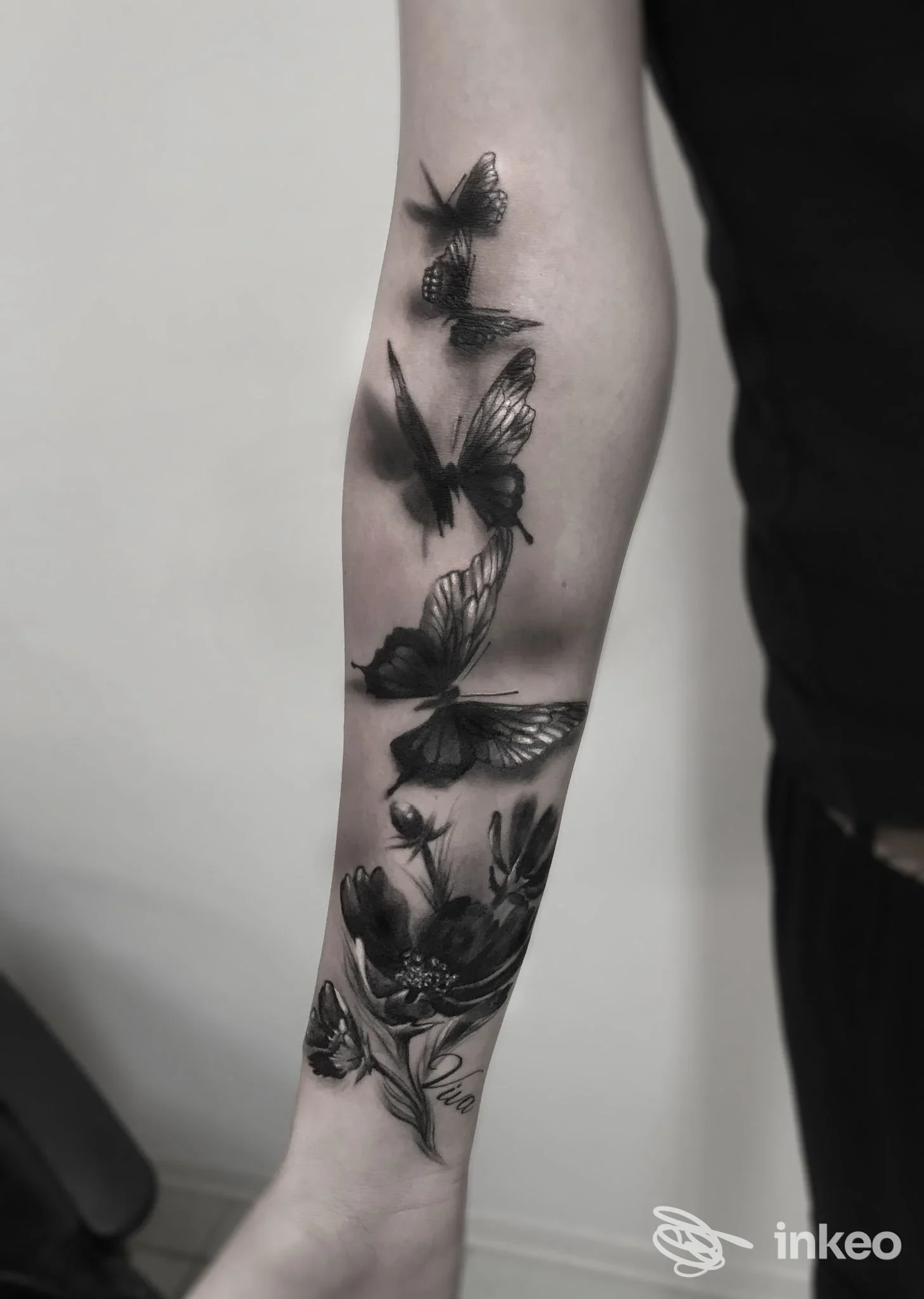 Tatuaggio realistico in bianco e nero con farfalle e fiori sull'avambraccio, Oriental Tattoo Studio, Pistoia.