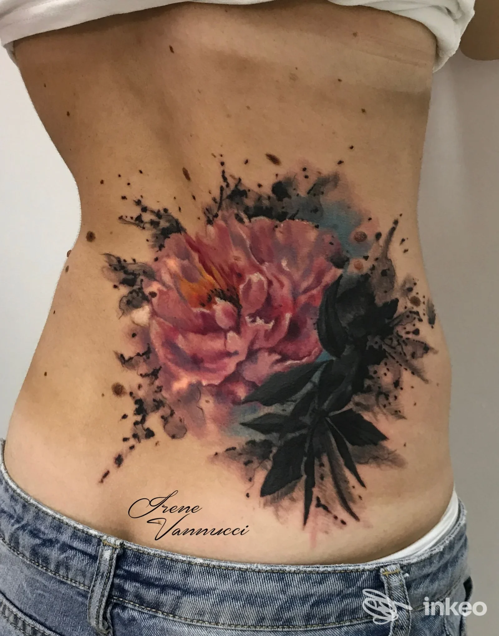 Grande tatuaggio floreale colorato sul fianco/basso addome, foto fornita da Oriental Tattoo Studio a Pistoia.