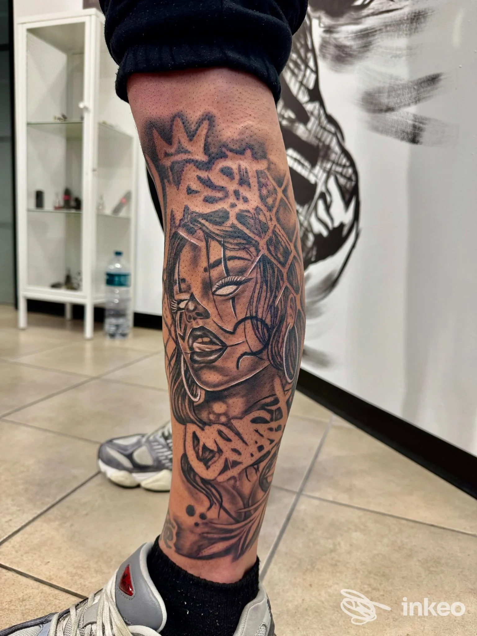 Fotografia del tatuaggio al polpaccio realizzato presso Reflex Ink Tattoo Studio a Monsummano Terme, ritratto stilizzato in bianco e nero.