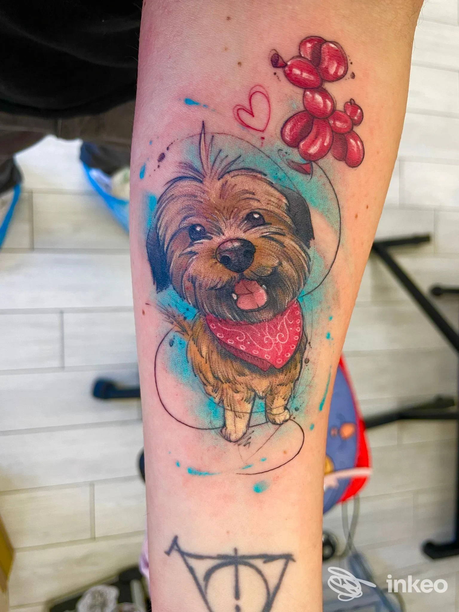 Tatuaggio su avambraccio raffigurante un cane con bandana e palloncino, Sweety J Tattoo, Grosseto.