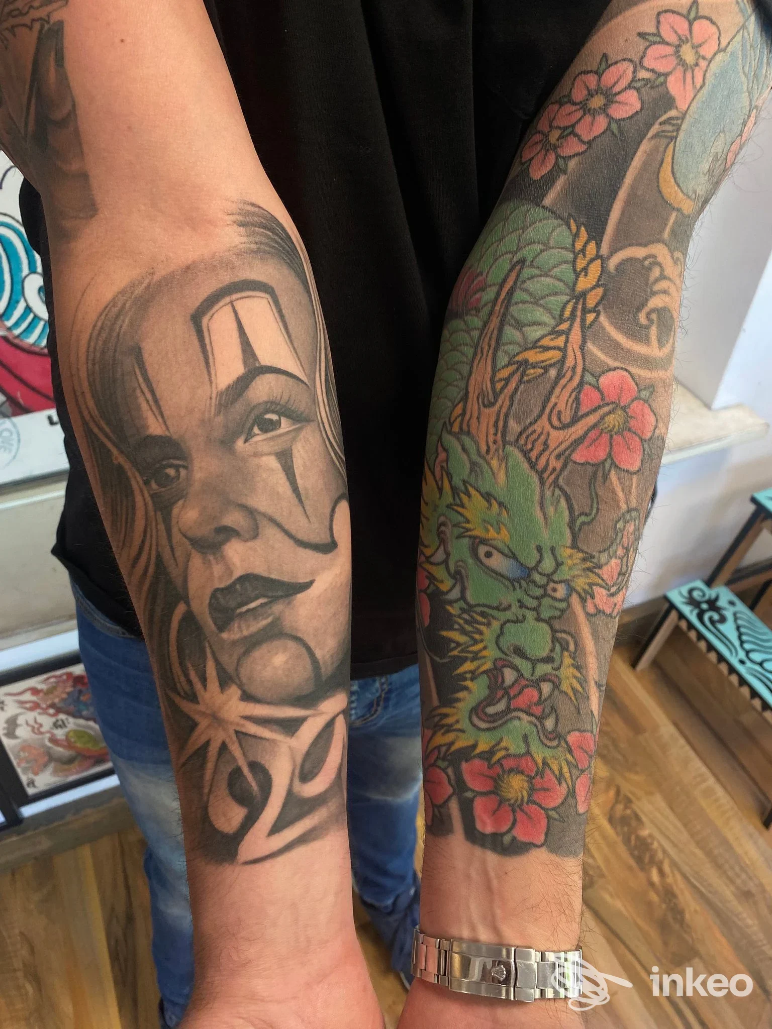 Due avambracci tatuati: ritratto in bianco e nero su un braccio e manica colorata con drago e fiori. Tattooing With Love, Monsummano Terme.