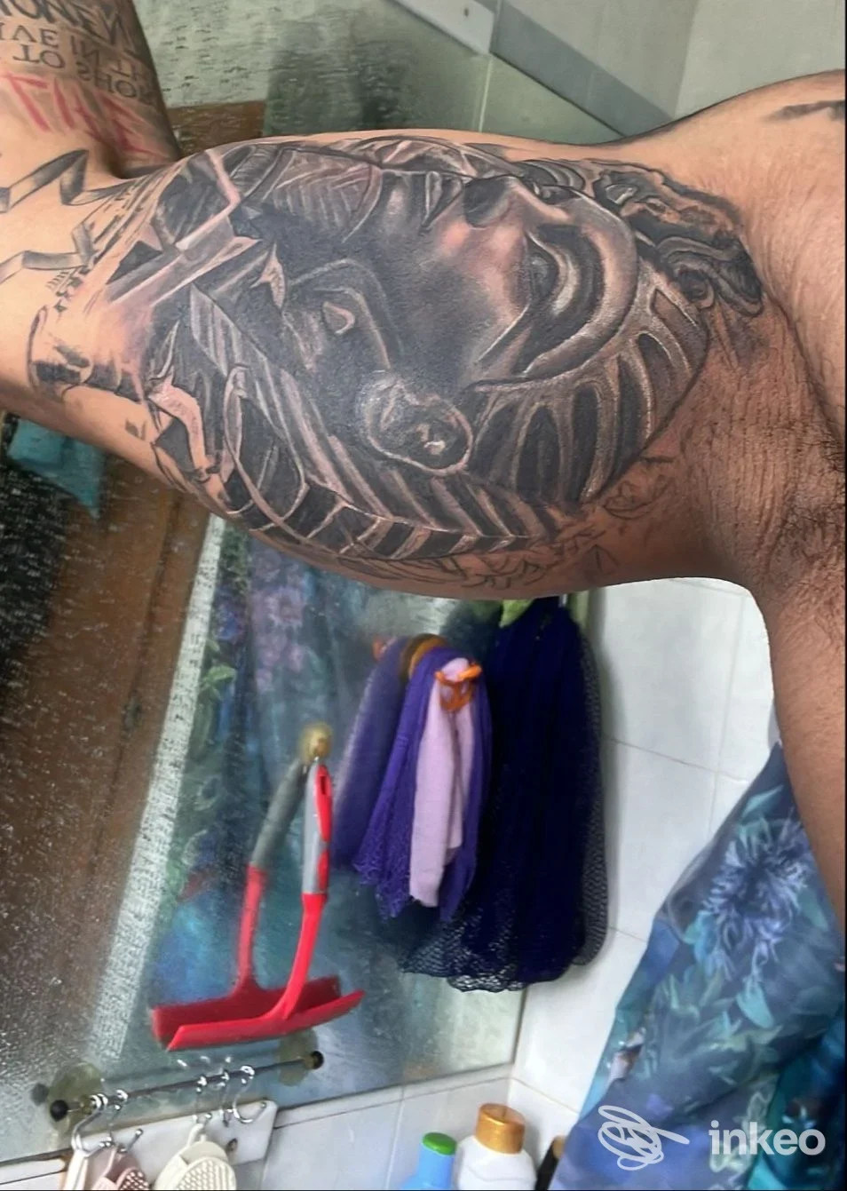 Braccio con tatuaggio black and grey raffigurante un volto stilizzato; immagine fornita da Alpha Omega Tattoo, Trento.