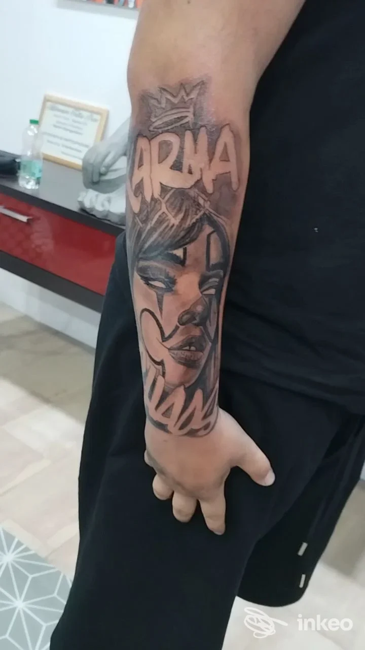 Tatuaggio black & grey su avambraccio con lettering e ritratto femminile, foto scattata nello studio Alpha Omega Tattoo a Trento.