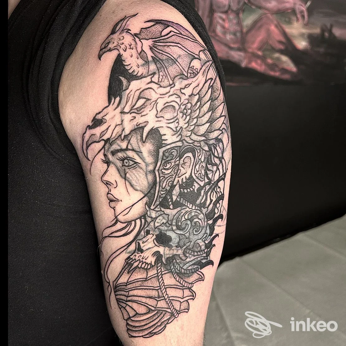 Tatuaggio in bianco e nero sul braccio con volto femminile, teschio e drago, foto fornita da Bootleg Art Tattoo a Riva del Garda.