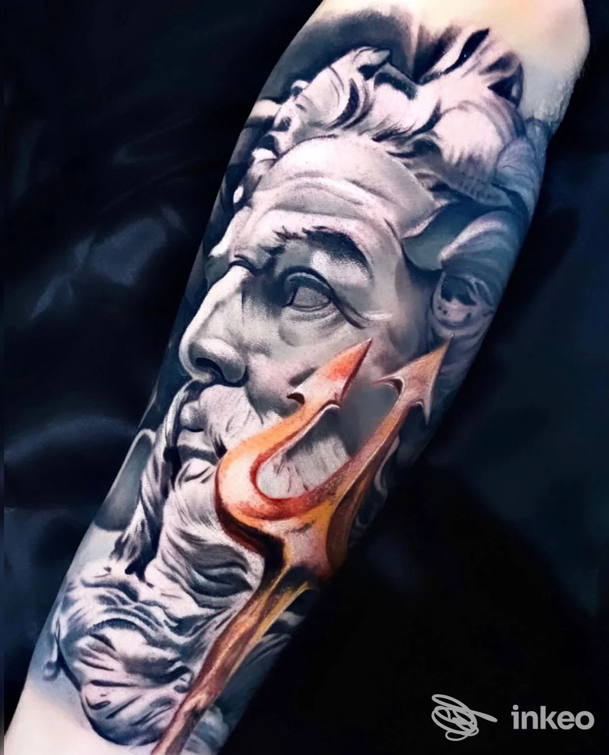 Tatuaggio realistico su avambraccio raffigurante volto scultoreo e tridente, Holy Body Arts Piercing und Tattoo, Merano.