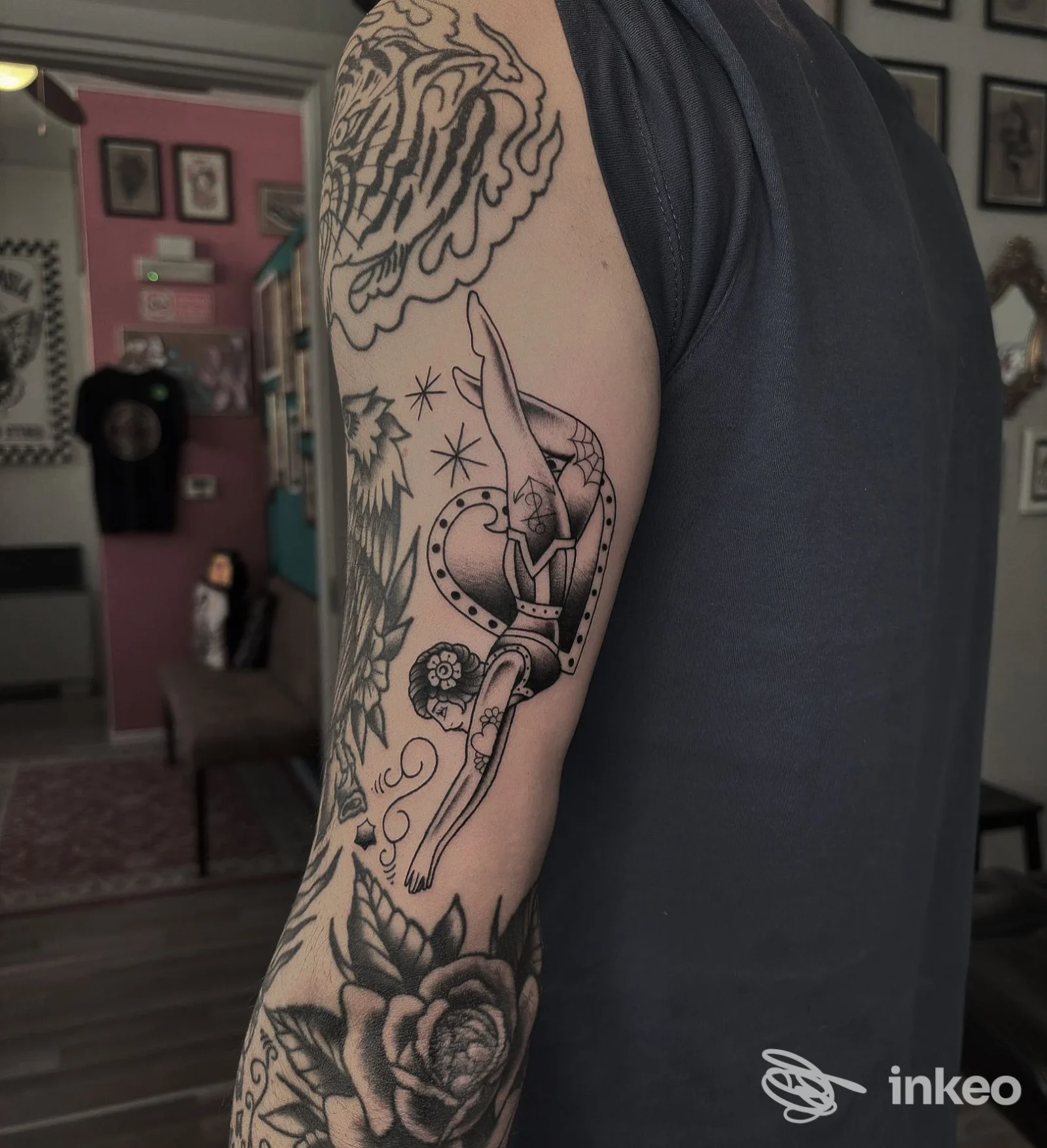 Tatuaggio nero/grigio su braccio superiore con figura femminile e rose, foto di Inkmate Tattoo Studio a Levico Terme.