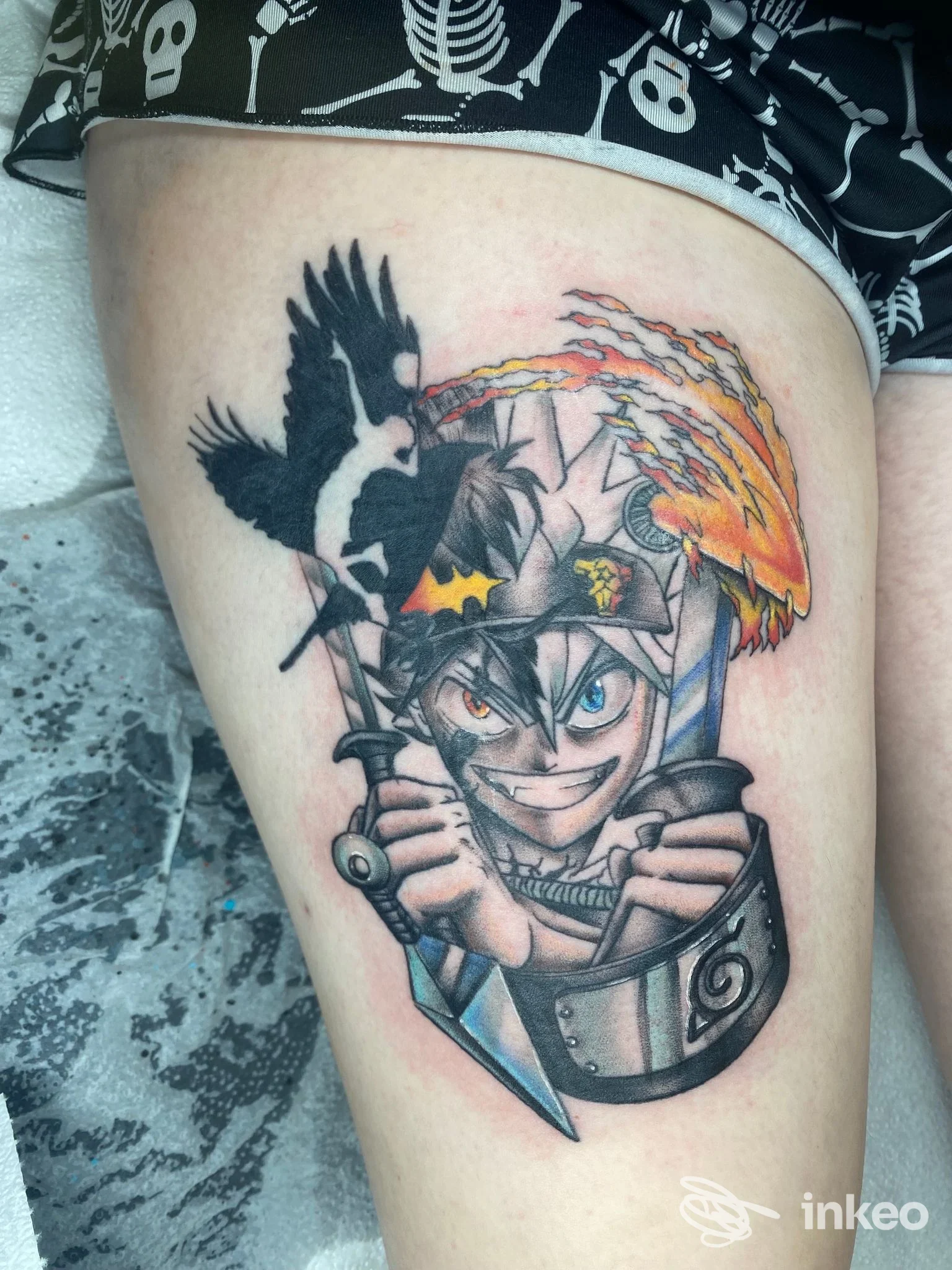 Tattoo su coscia con personaggio in stile anime, corvo e fiamma. Isc Tattoo Di Caruso Salvatore, Rovereto.