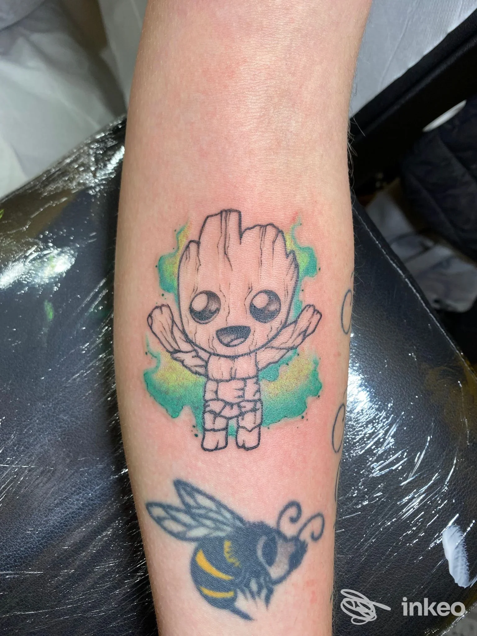 Tatuaggio su avambraccio con Baby Groot colorato e ape stilizzata, immagine fornita da Isc Tattoo Di Caruso Salvatore, Rovereto.