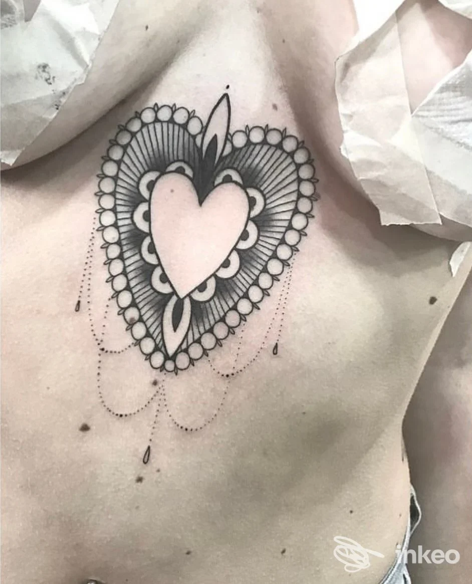 Tatuaggio ornamentale a cuore in nero sullo sterno, La Maggie Tattoo Studio a Primiero San Martino di Castrozza.