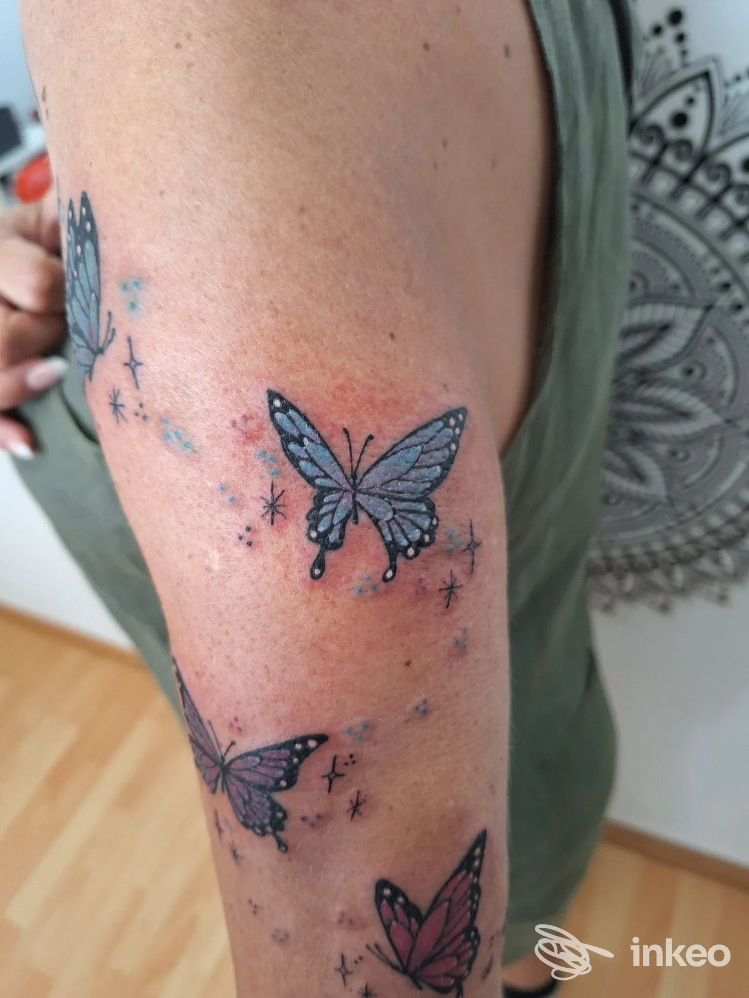 Braccio con tatuaggi a farfalla colorati e stelline, foto inviata dallo studio Mad Queen Tattoo a Bolzano.