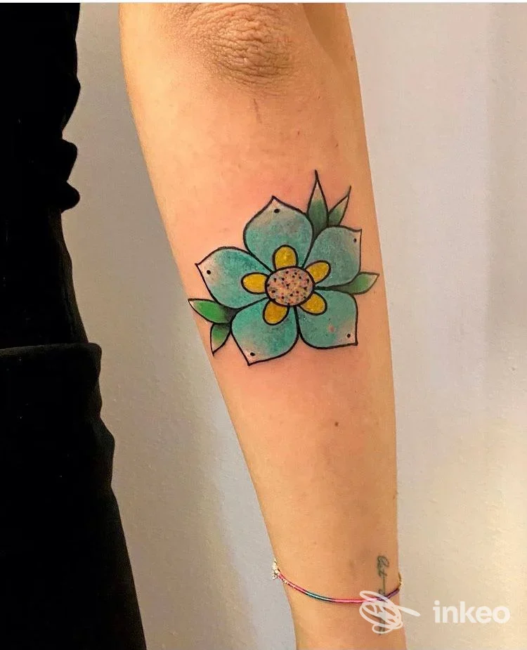 Avambraccio con tatuaggio a fiore colorato, foto inviata da Naïf Studio Tattoo a Pinzolo.
