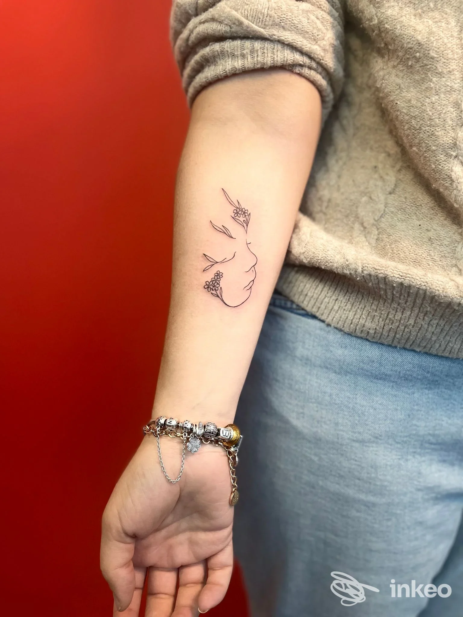 Piccolo tatuaggio lineare di volto sul lato interno dell'avambraccio, foto di NovaTattooStudio a Mattarello.