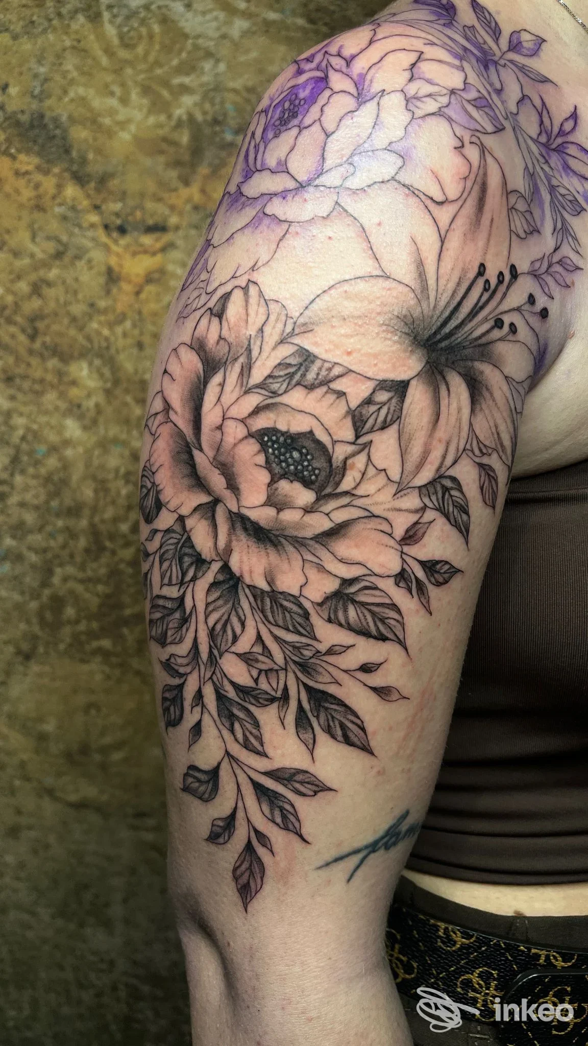 Tatuaggio floreale a linee e ombreggiature sul braccio e spalla, foto dello studio Ornamentum Tattoo-Art by Flora a Siusi.