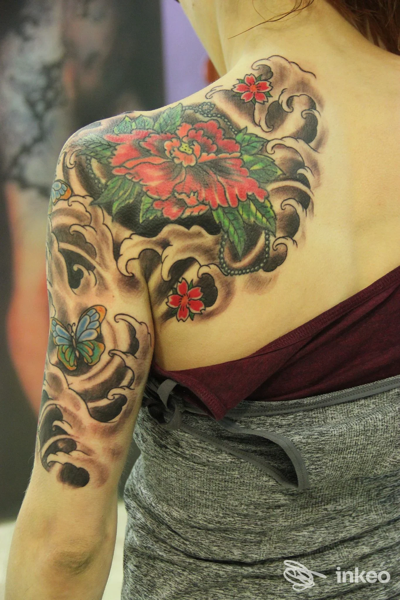 Ampio tatuaggio floreale e farfalla sulla spalla e braccio superiore, fotografia fornita da Red Dragon Tattoo di Rosario Vicenzi, Pellizzano.
