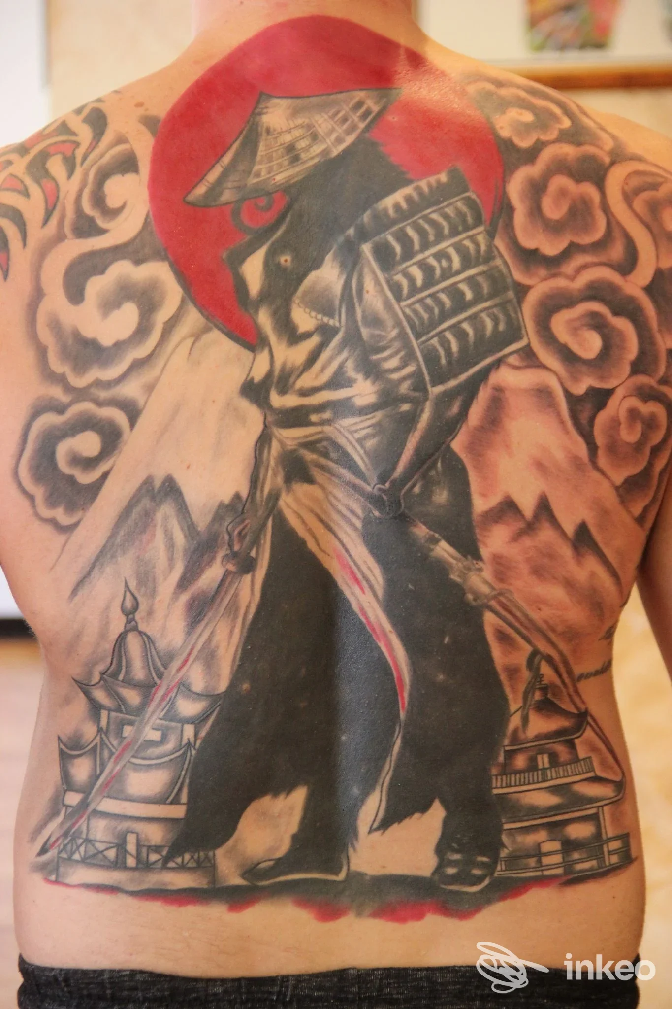 Grande tatuaggio a tutta schiena con samurai in nero e disco solare rosso, foto fornita da Red Dragon Tattoo, Pellizzano.