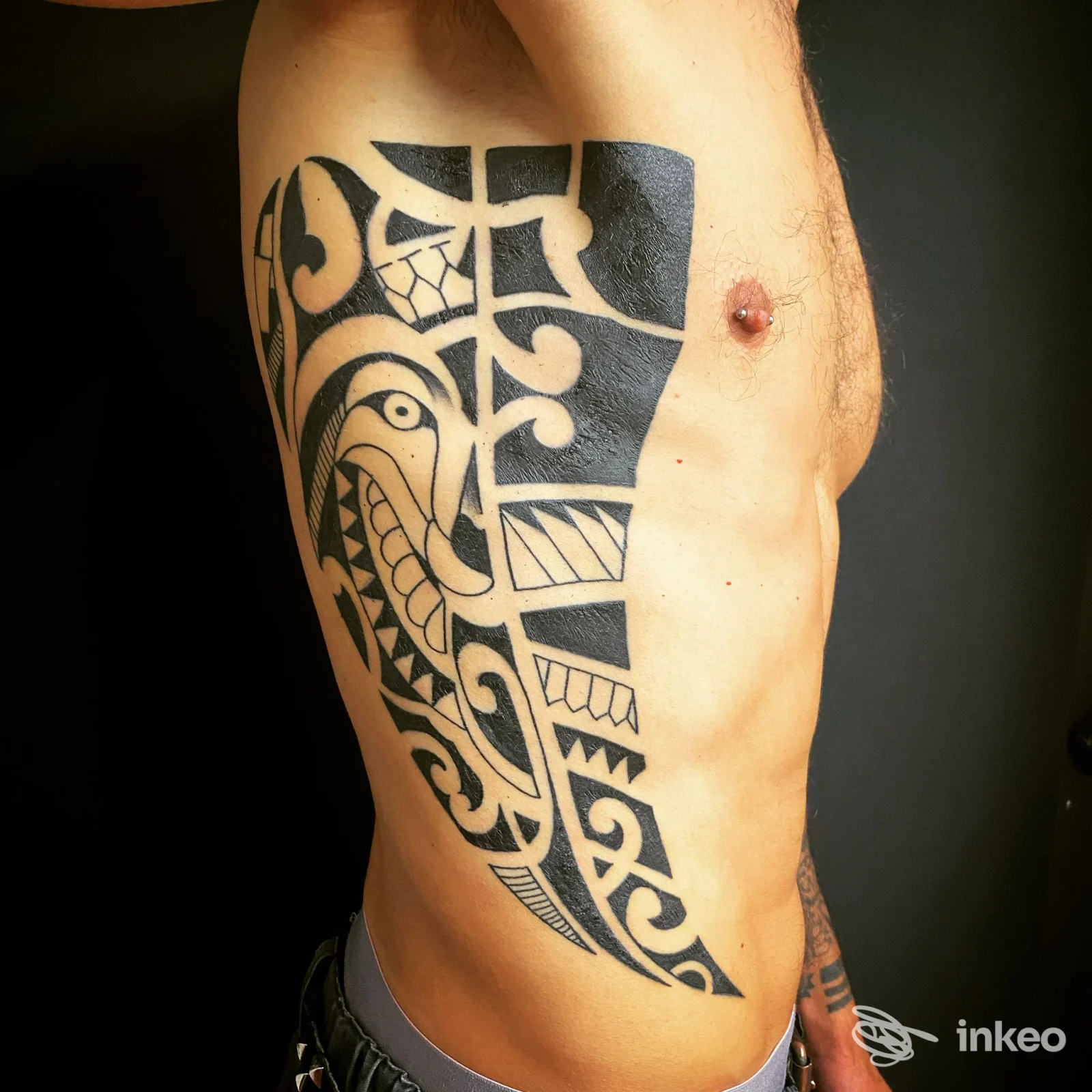 Ampio tatuaggio tribale nero sul fianco destro di un uomo, fotografia promozionale per SKY TATTOO BRUNECK a Brunico.