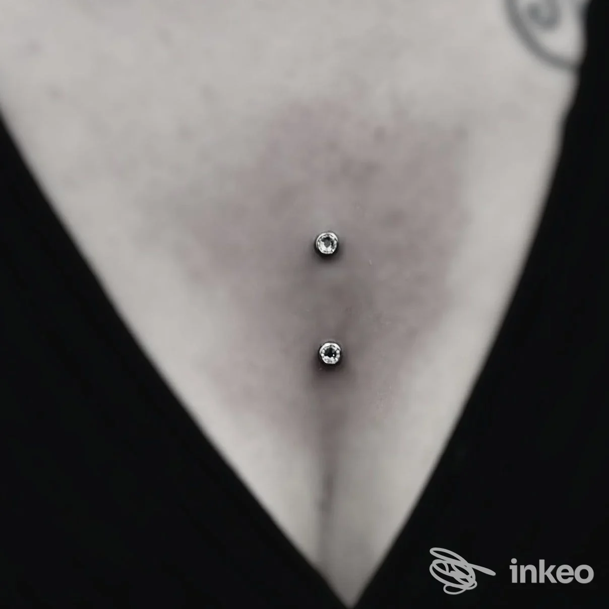 Primo piano di piercing sternale con due gemme, foto fornita da Skink Tattoo & Piercing a Bolzano.