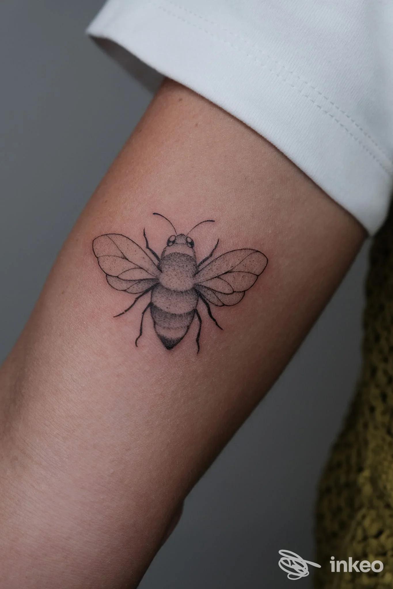 Tatuaggio di ape in bianco e nero sull'avambraccio interno, linework fine con sfumature a puntinato. Studio 9 tattoo, Bolzano.