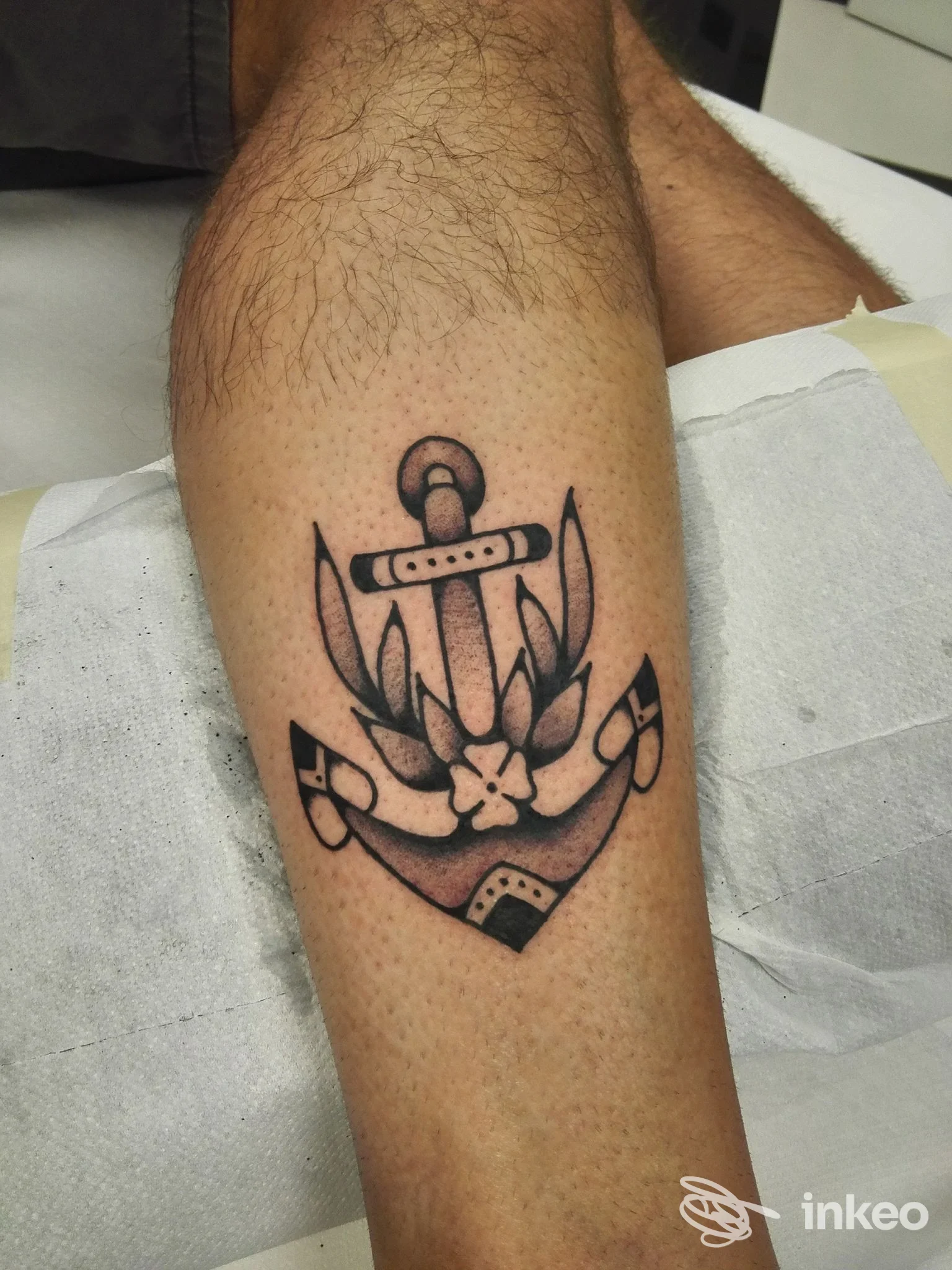 Tatuaggio a inchiostro nero a forma di ancora sul polpaccio, foto fornita da Studio Vertigo - Tatuaggi e Piercing, Trento.