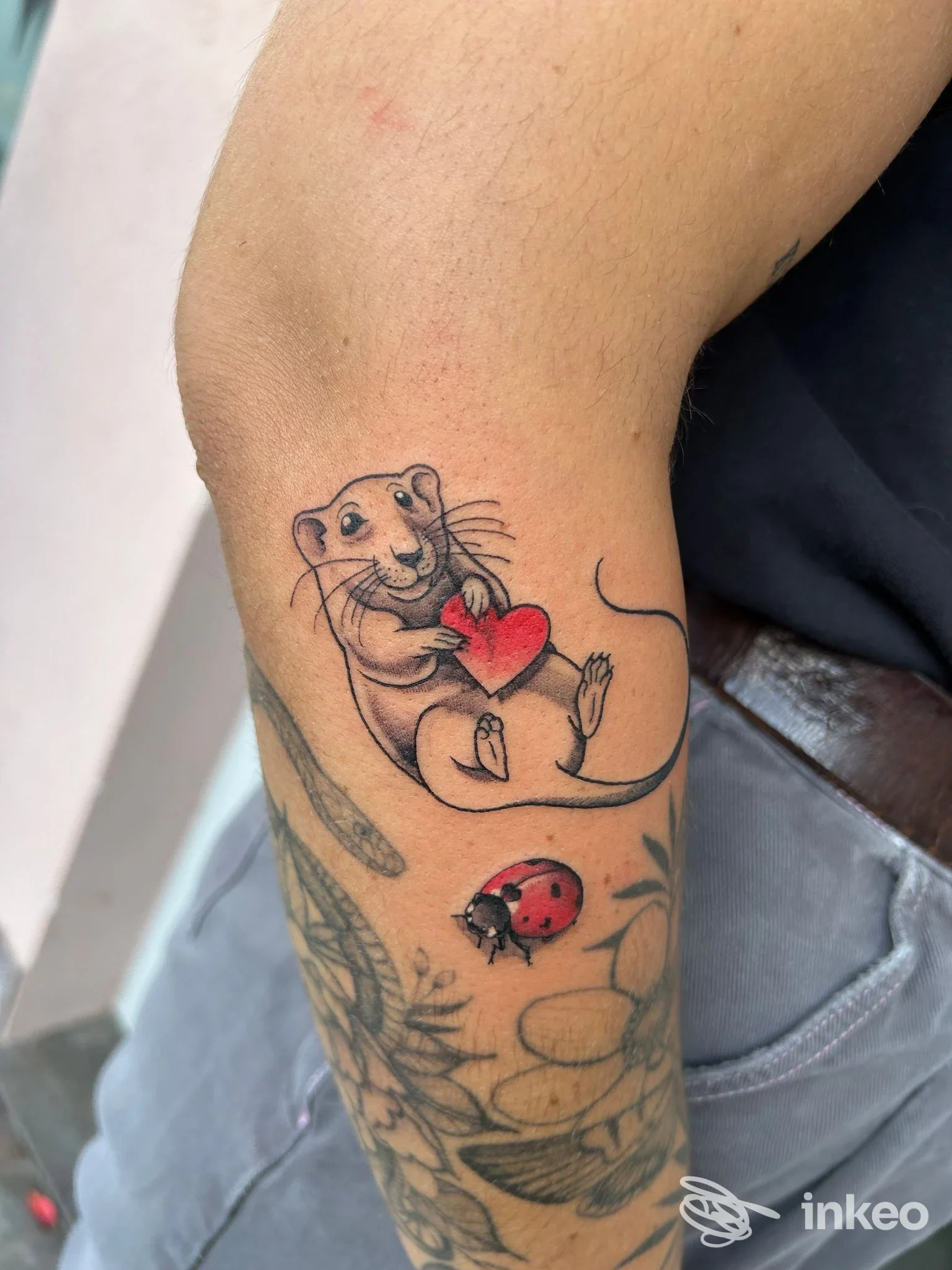 Tatuaggio di topo con cuore e coccinella sull'avambraccio, TANUKI TATTOO SHOP, Lavis.