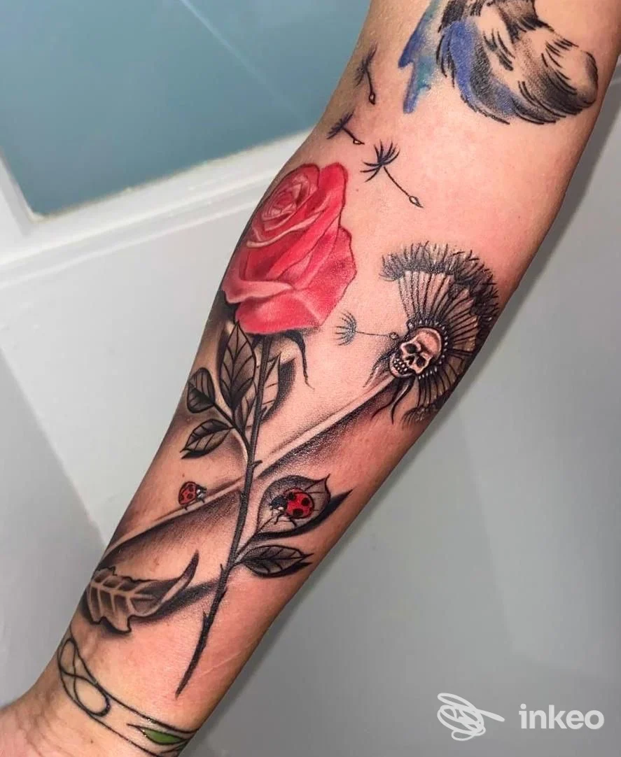 Tatuaggio su avambraccio con rosa rossa, soffione e dettagli su pelle reale — Tattoo Fatline, Bolzano.
