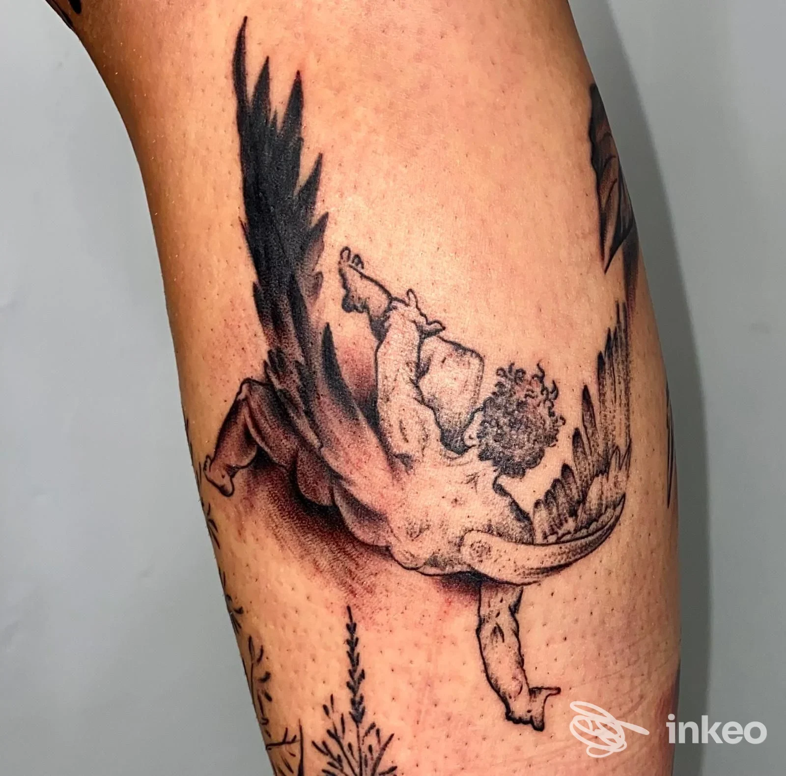 Dettagliato tatuaggio figurativo in bianco e nero di un angelo alato sul polpaccio, con sfumature puntinate e ombreggiature, realizzato da Tattoo Fatline a Bolzano.