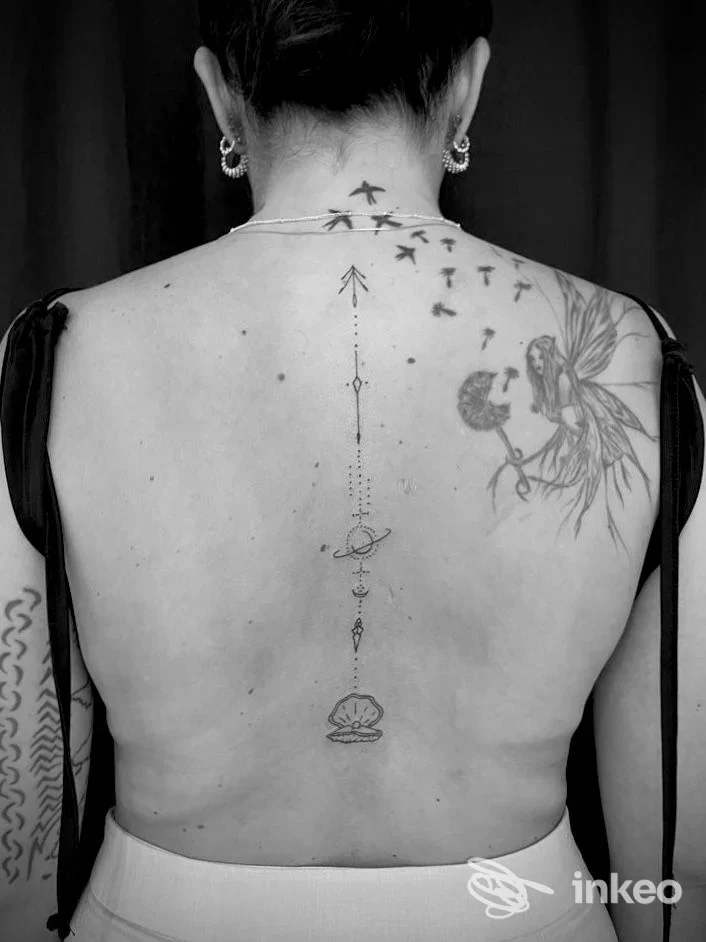 Tatuaggi sulla schiena con linea centrale e figura floreale, fotografia per Tattoo Giovanett a Trento.